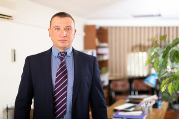 Portrait of focused executive business man standing in office
