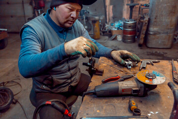 Portrait of a welder with a microphone in his ear at the workplace
