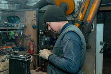 Obraz na płótnie Canvas Welder solders copper car radiator with gas torch