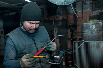 Welder solders copper car radiator with gas torch