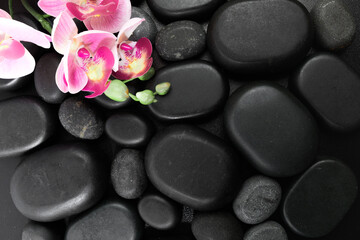 Spa stones  and flowers on black background .