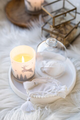 Cozy home decor with faux fur blanket, burning candles and interior decorations