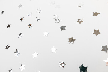 Obraz na płótnie Canvas star silver confetti on white background flat lay text place .