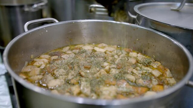 wsypywanie zi&oacute;ł do gotującej się zupy, gotowanie zupy, wsypywanie majeranku do zupy / pouring herbs into boiling soup, cooking soup, pouring marjoram into soup 