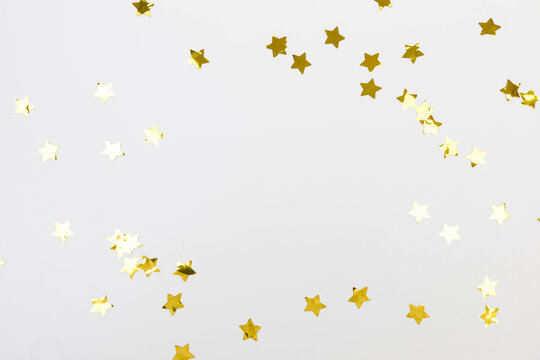 golden confetti on white background flat lay text place .