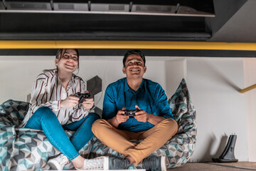 Work hard play hard. Workers Playing computer games man against woman during break in relaxation area at creative startup Office