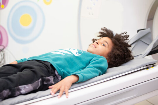 A boy in a magnetic resonance imaging machine in a hospital.
