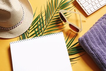 Summer travel mockup. Sun hat, palm leaves, white paper sheet, sunglasses, towel and computer keyboard view from above photography, flat lay image, free space for text