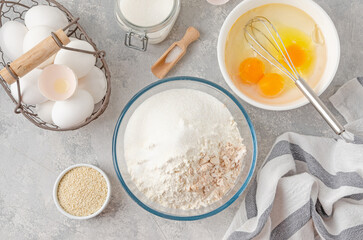 Ingredients for making sweet bread, brioche or challah bread. Yeast, flour, eggs, milk on a gray concrete background. Top view.