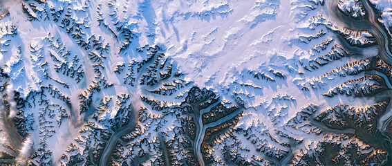 Shedding light on Greenland, satellite image, Greenland ice sheet and its edges, melt ponds, snowy mountain peaks cast long shadows in the evening sunlight. Elements of this image furnished by NASA - obrazy, fototapety, plakaty