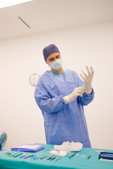 Male surgeon putting his sterile gloves and preparing for a surgery