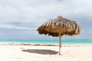 Wooden umbrella stands on an empty sandy beach