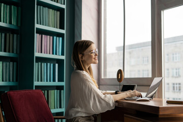 Financier workplace video call uses laptop computer. A student with glasses in the office in the...