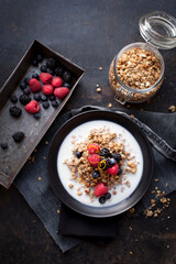 Healthy breakfast with muesli, rice milk and berries on dark background
