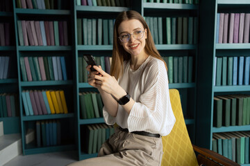 uses the phone writes a message manager woman working in the office report place. A student with glasses in the library.