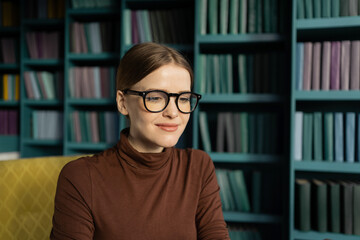 A woman with glasses reads a portrait in the office