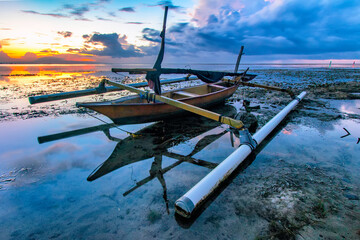 Fototapeta na wymiar Fishing boat at karang beach on a beautiful sunrise.