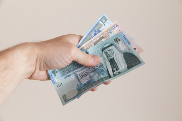 A hand holding Jordanian dinars banknotes, close up - obrazy, fototapety, plakaty
