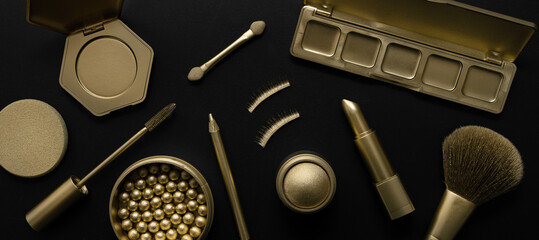 luxury cosmetics - set with golden makeup beauty products on black background. banner