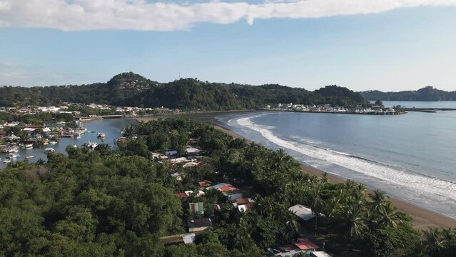The port city of Quepos, Costa Rica on a sunny day viewed from Isla Damas. Ascending aerial shot