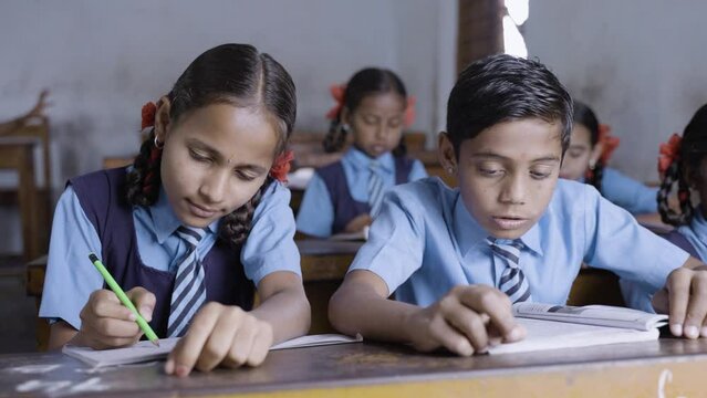 kids busy studying at classroom for examinations at school - concept of Indian education, childhood development and learning