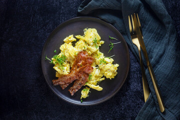 Scrambled eggs with fried bacon