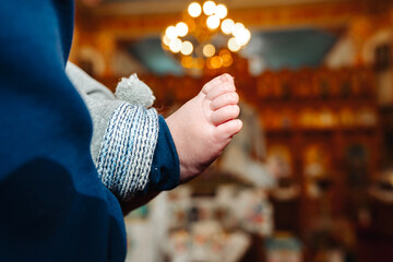 The sacrament of the baptism of a child in an Orthodox church, the priest anoints the baby's feet...