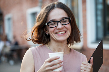 Portrait of young smiling smart business woman smiling drinking coffee