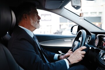 Mature successful businessman riding in the car.