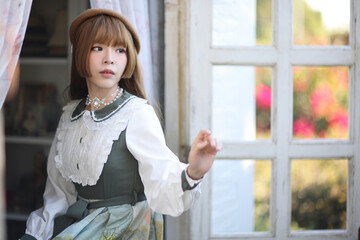 A beautiful woman in lolita dress in garden background Japanese street fashion portrait