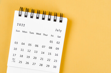 July 2022 desk calendar on light yellow background.