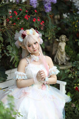 Beautiful young woman with white lolita dress with flowers garden Japanese fashion