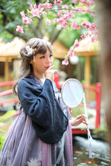 Beautiful young woman with dark blue Chinese lolita dress with Chinese garden