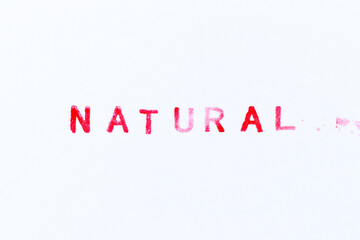 Red color ink rubber stamp in word natural on white paper background