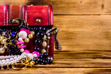 Old box of red wood full of the jewelry. Treasure chest