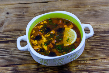 Russian traditional hodgepodge soup on a wooden table