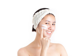 Beautiful half naked model young woman applying cosmetic cream treatment on her face isolated on...