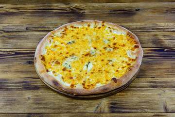 Pizza quattro formaggi (four cheeses) on a wooden background
