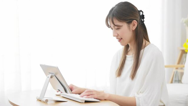 タブレットパソコンを使う若い女性