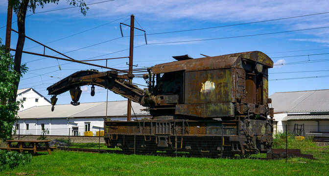 View of a Rusting of Train Steam Crane sitting on a Track Rusting Away on a Sunny Day
