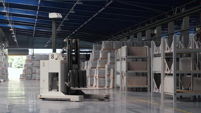 Modern production, automatic robot loader moves among the racks, logistics warehouse in the production of a tile factory