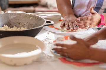 Obraz na płótnie Canvas Unknown persons preparing tortillas in an artisanal manner 