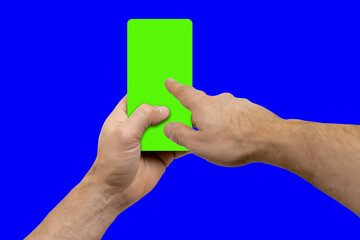 Young man clicking on mobile phone with green screen. Chroma key for content, the device is located frontally flat lay