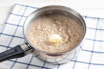 Barley porridge with butter in a saucepan. Recipe step by step