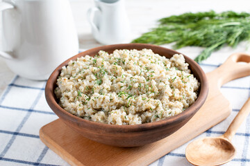 Barley porridge with dill and vegetables in a bowl