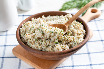 Barley porridge with dill and vegetables in a bowl