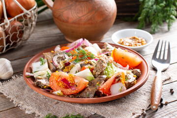 Warm salad with chicken liver, tomatoes and salad mix in a plate