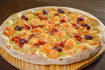 Pizza. Shrimp pizza with olives on wooden shovel close-up.