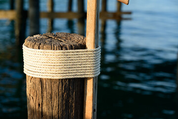 A round wooden pole that was wrapped in hemp rope many times for used as a pole to moor ships.