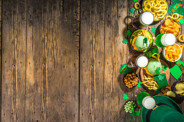 St Patrick`s holiday party invitation, bar menu background. Irish St Patrick`s day beer, ale glasses, snacks, appetizer, green burger, wooden bar table with shamrock, clover, coins, leprechaun hat 